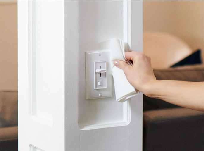 Person cleaning off light switch with Viva Paper Towels